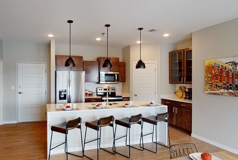 a kitchen with a large island with bar stools