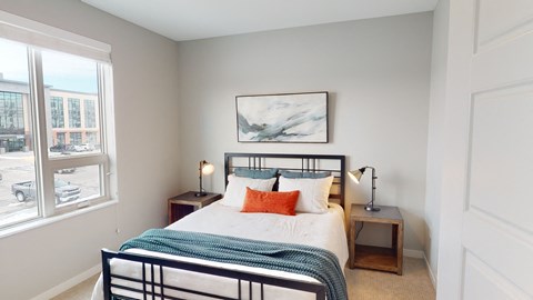 a bedroom with a bed and a large window