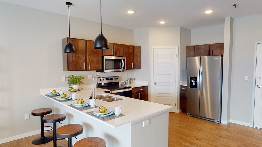 a kitchen with a large island and a stainless steel refrigerator