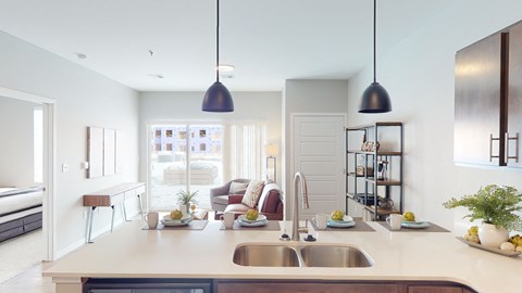 a kitchen with a sink and a counter and a living room