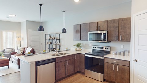 a kitchen and living room with wooden cabinets and stainless steel appliances