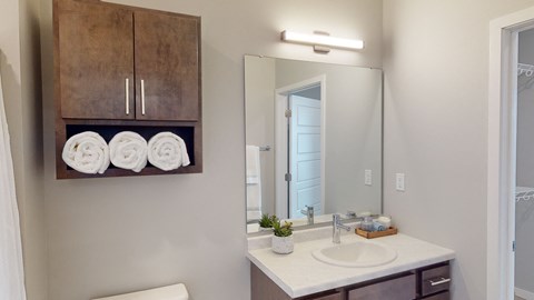 a bathroom with a large mirror and a sink with towels