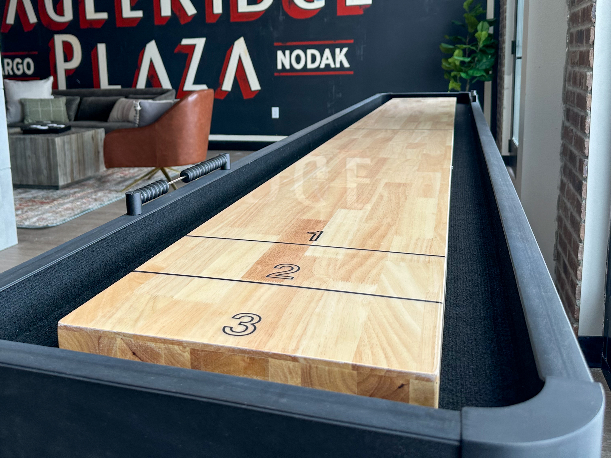 a shuffleboard table in a room with a brick wall