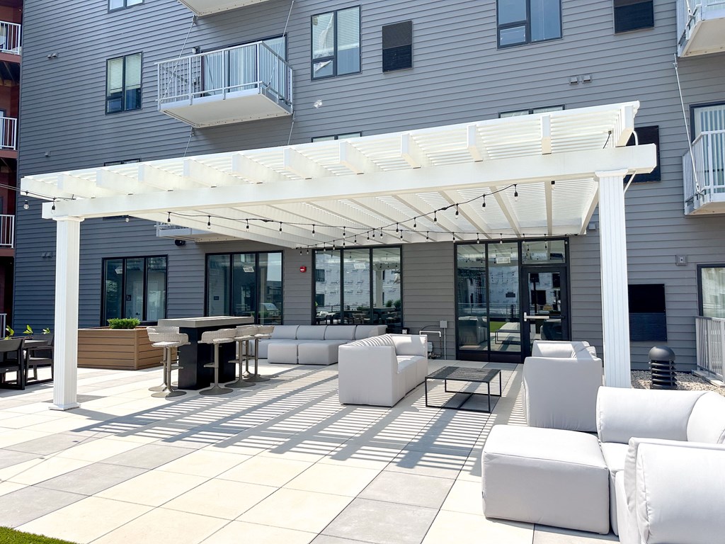 a patio with white furniture and a white canopy