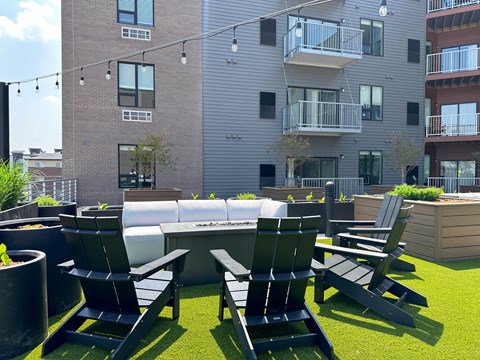 a seating area with chairs and a table in front of an apartment building