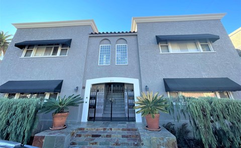 A house with a grey facade and a black awning.