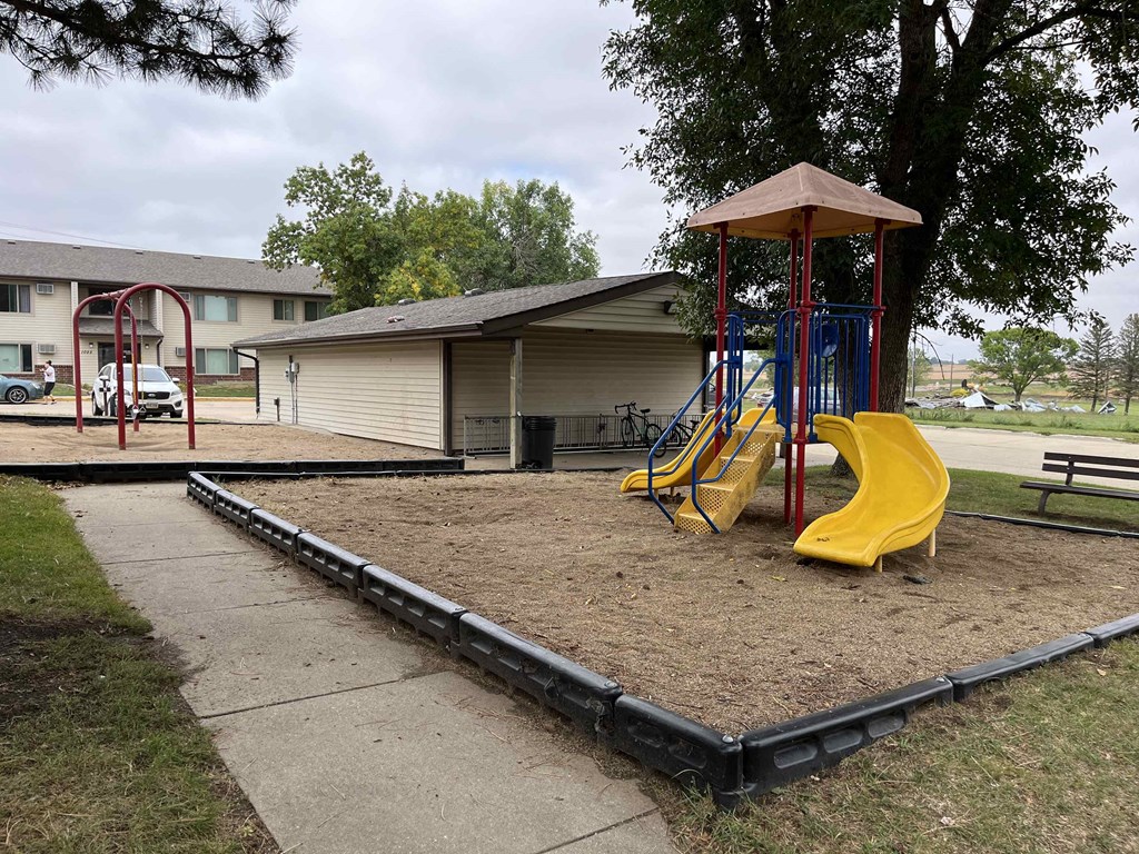 a playground with slides and swings in a park