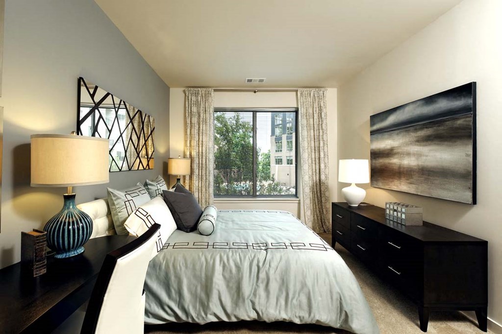 a bedroom with a bed and a large window