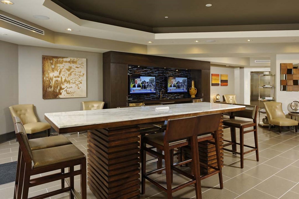 a large bar with chairs and a television in a lobby