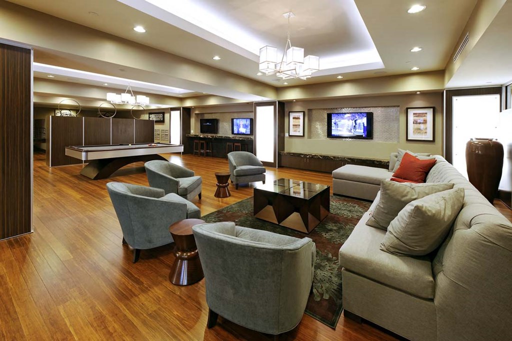 a living room with couches and chairs and a pool table