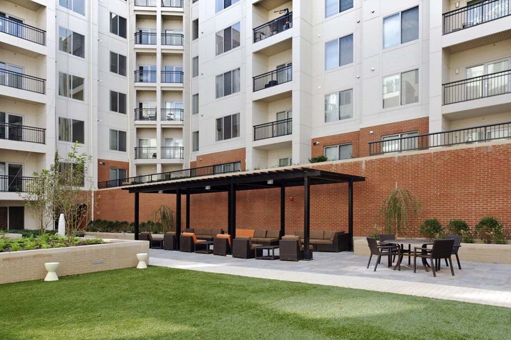 an outdoor patio with furniture in front of an apartment building