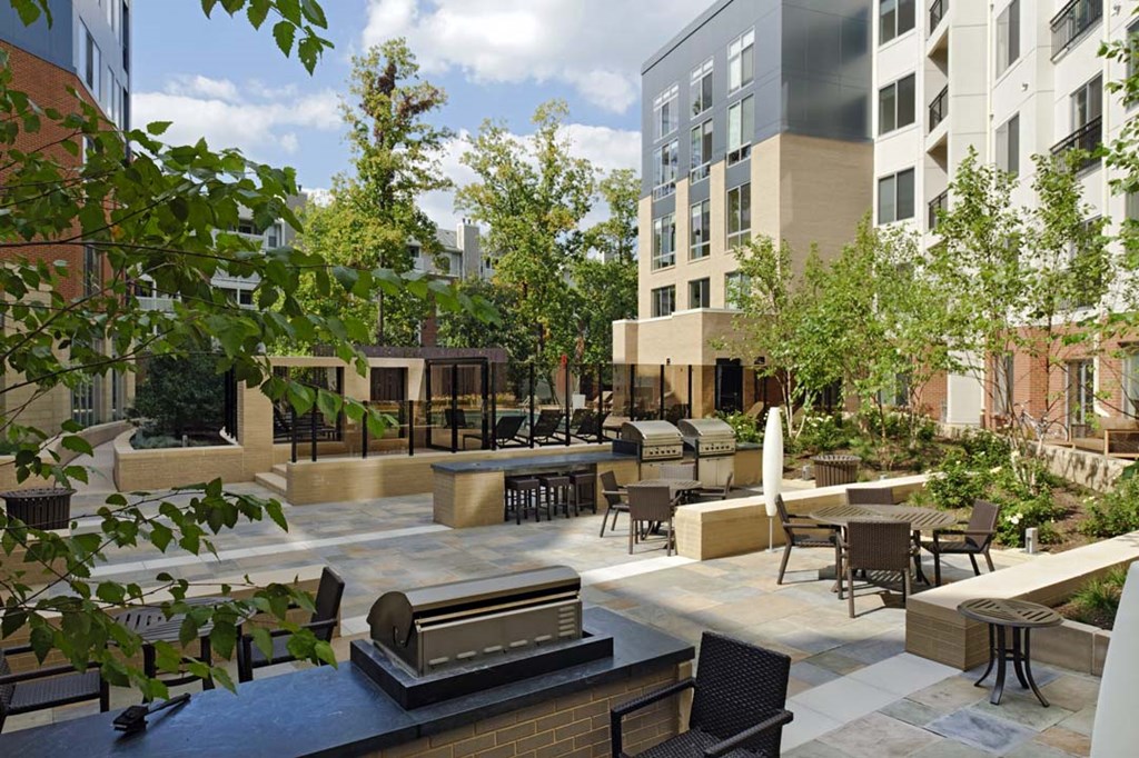 a rendering of a courtyard with tables and chairs at an apartment building