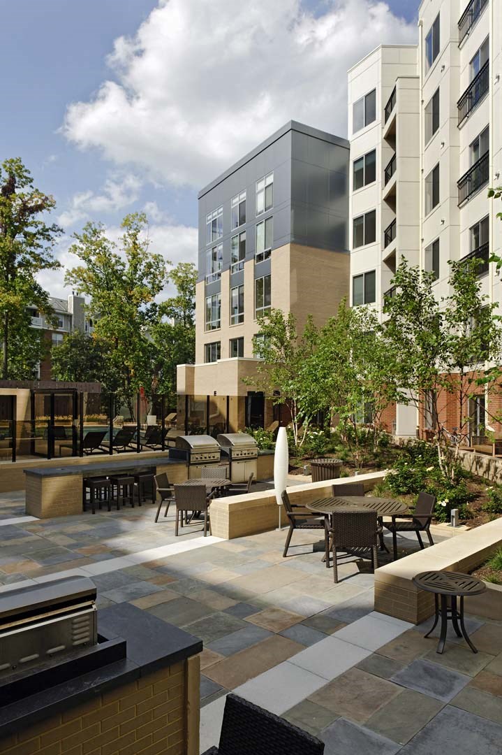 an open courtyard with tables and chairs and buildings