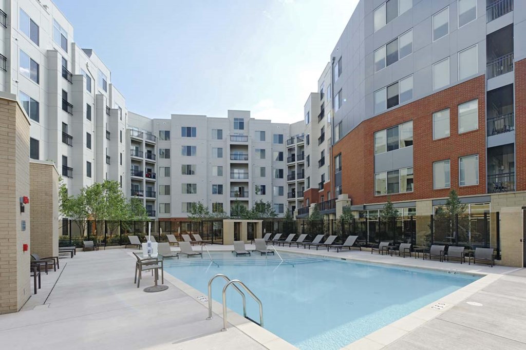 an empty swimming pool in front of an apartment building