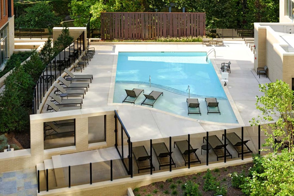 a swimming pool in a backyard with chairs