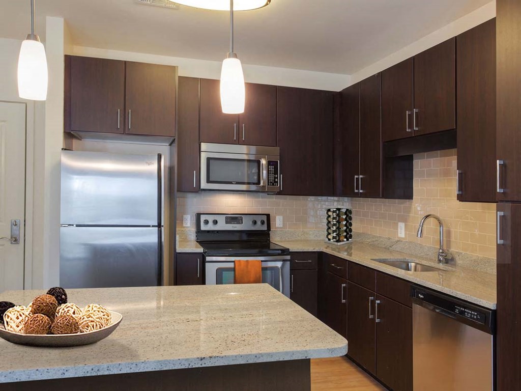 a kitchen with stainless steel appliances and a marble counter top