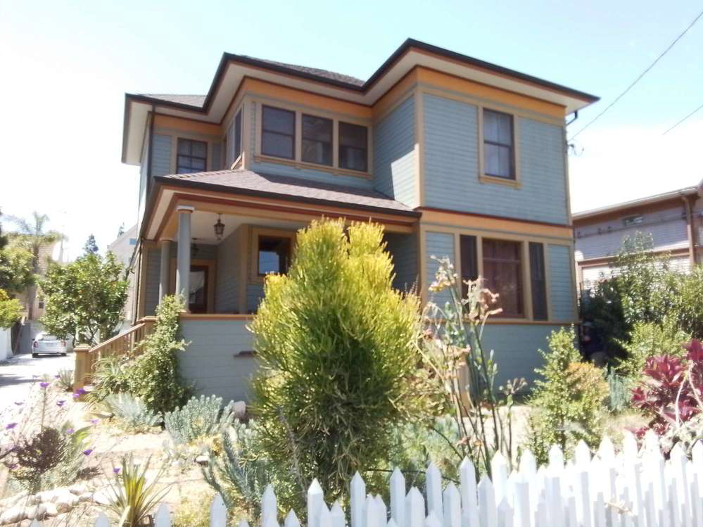a blue house with a fence in front of it
