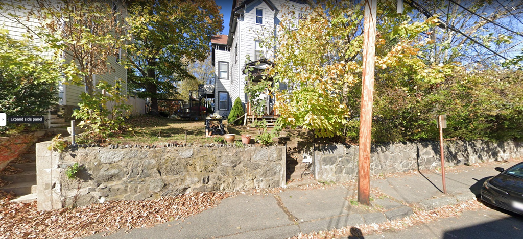a stone retaining wall in front of a house