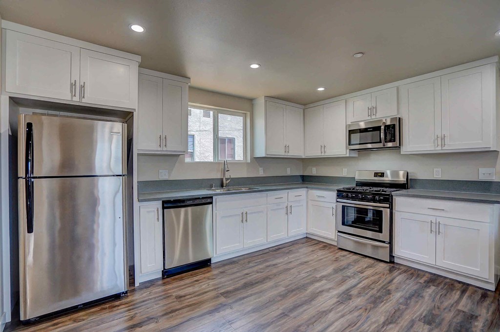 a kitchen with white cabinets and stainless steel appliances