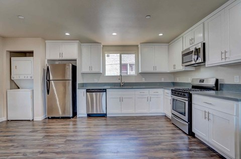 a kitchen with white cabinets and stainless steel appliances