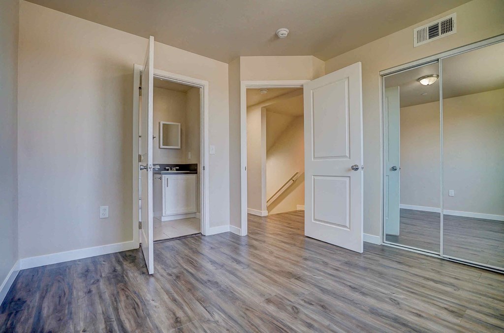 a living room with a door open to a hallway and a kitchen