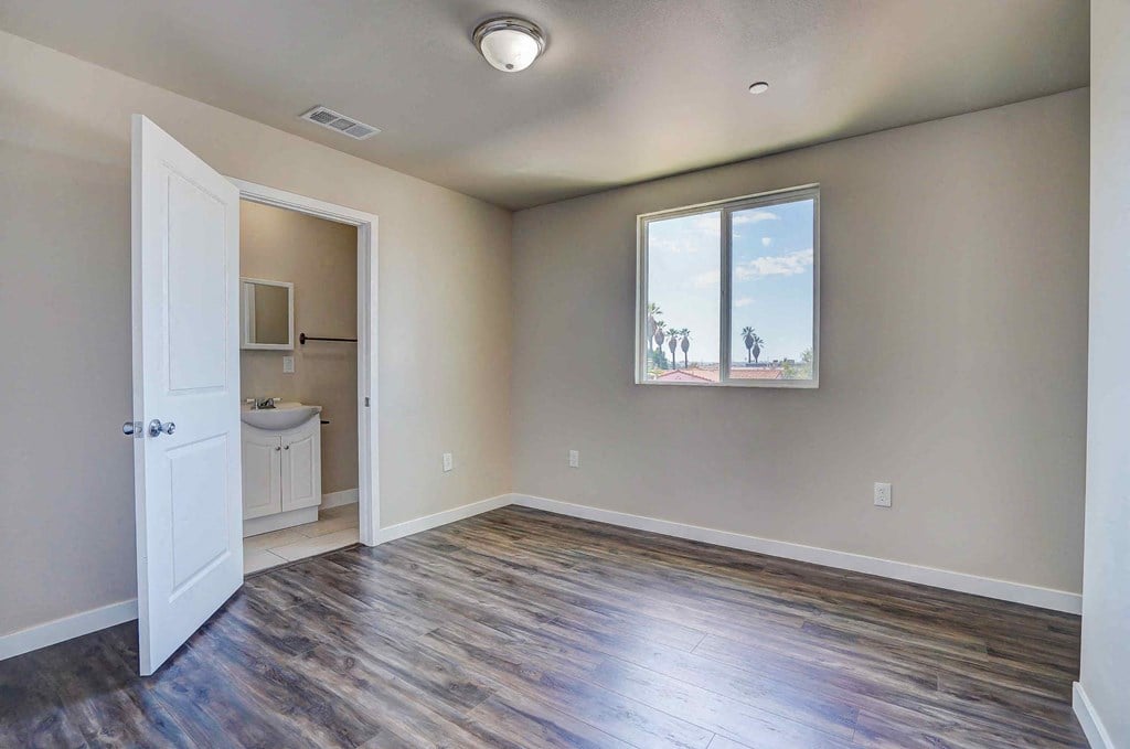 an empty living room with a white door and a window