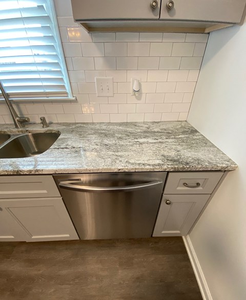 a kitchen with granite counter top and stainless steel sink