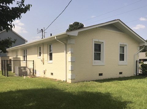a yellow house with a yard in front of it