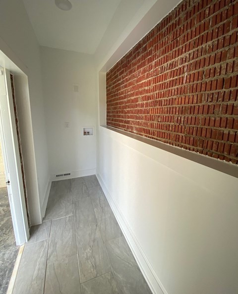 a brick wall in a hallway of a house