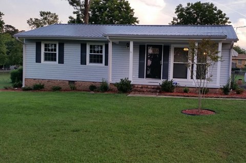 A small house with a tree in front of it.