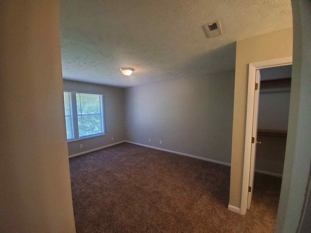 a empty room with a closet and a window