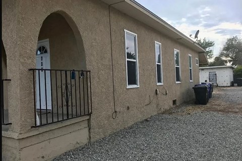 A building with a white door and windows with a black railing.