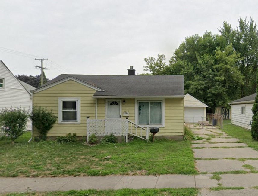 a small yellow house with a yard and a sidewalk
