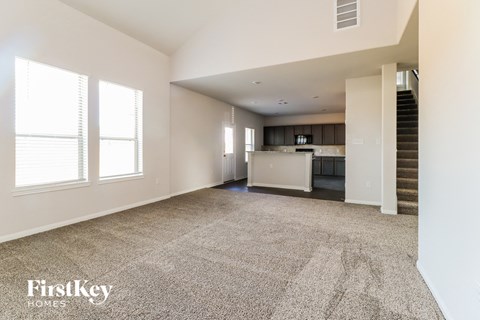 A spacious living room with a staircase leading to the upper floor.