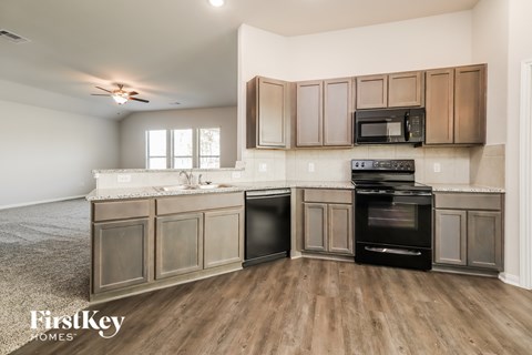 A kitchen with wooden floors and a black oven.