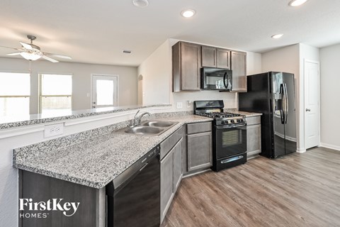 A kitchen with a FirstKey Homes sign on the countertop.