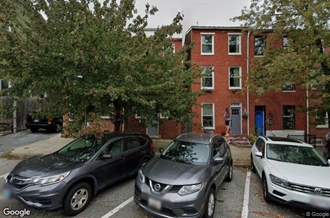 three cars parked in front of a red brick house
