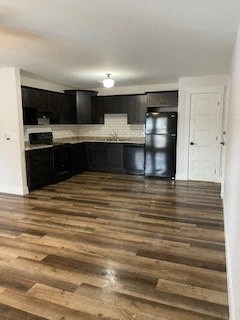 a kitchen with black cabinets and a wooden floor
