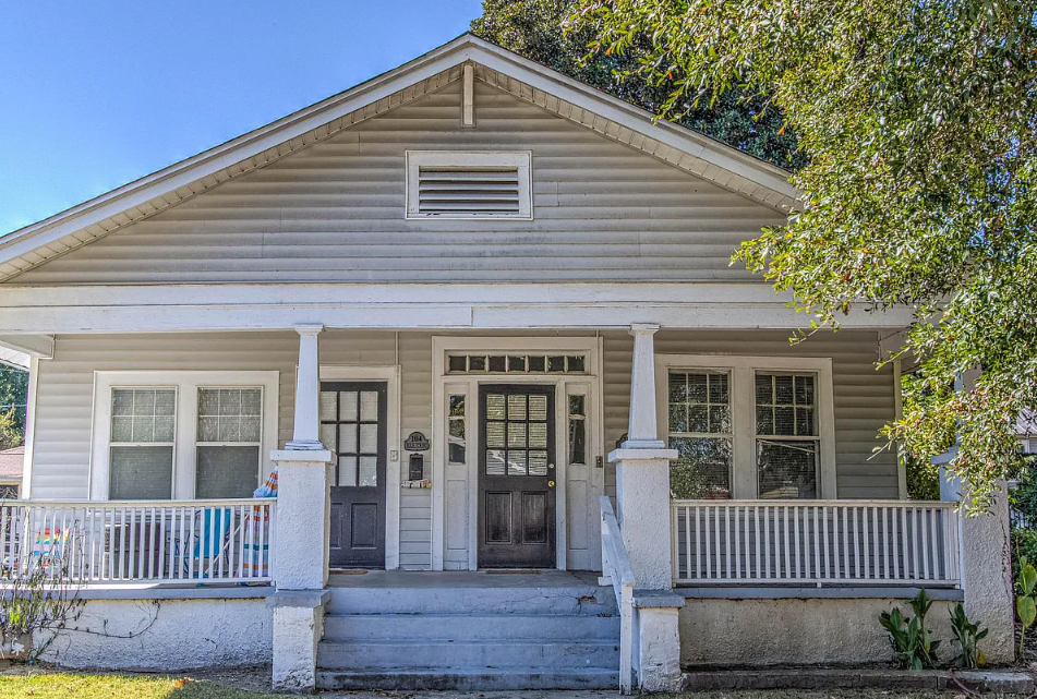 the front porch of a house with a porch swing