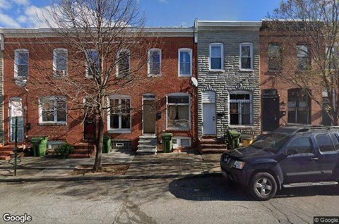 a car parked in front of a red brick house