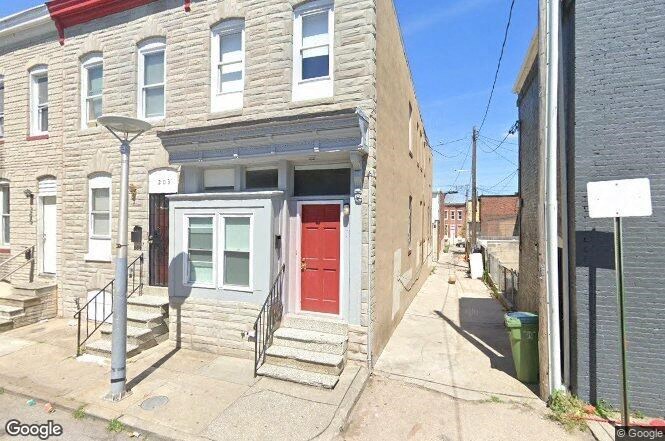 a small brick house with a red door
