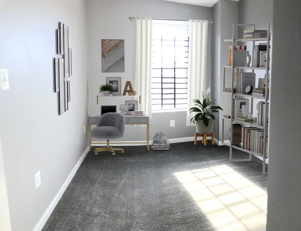 a living room with a gray carpet and a chair and a window
