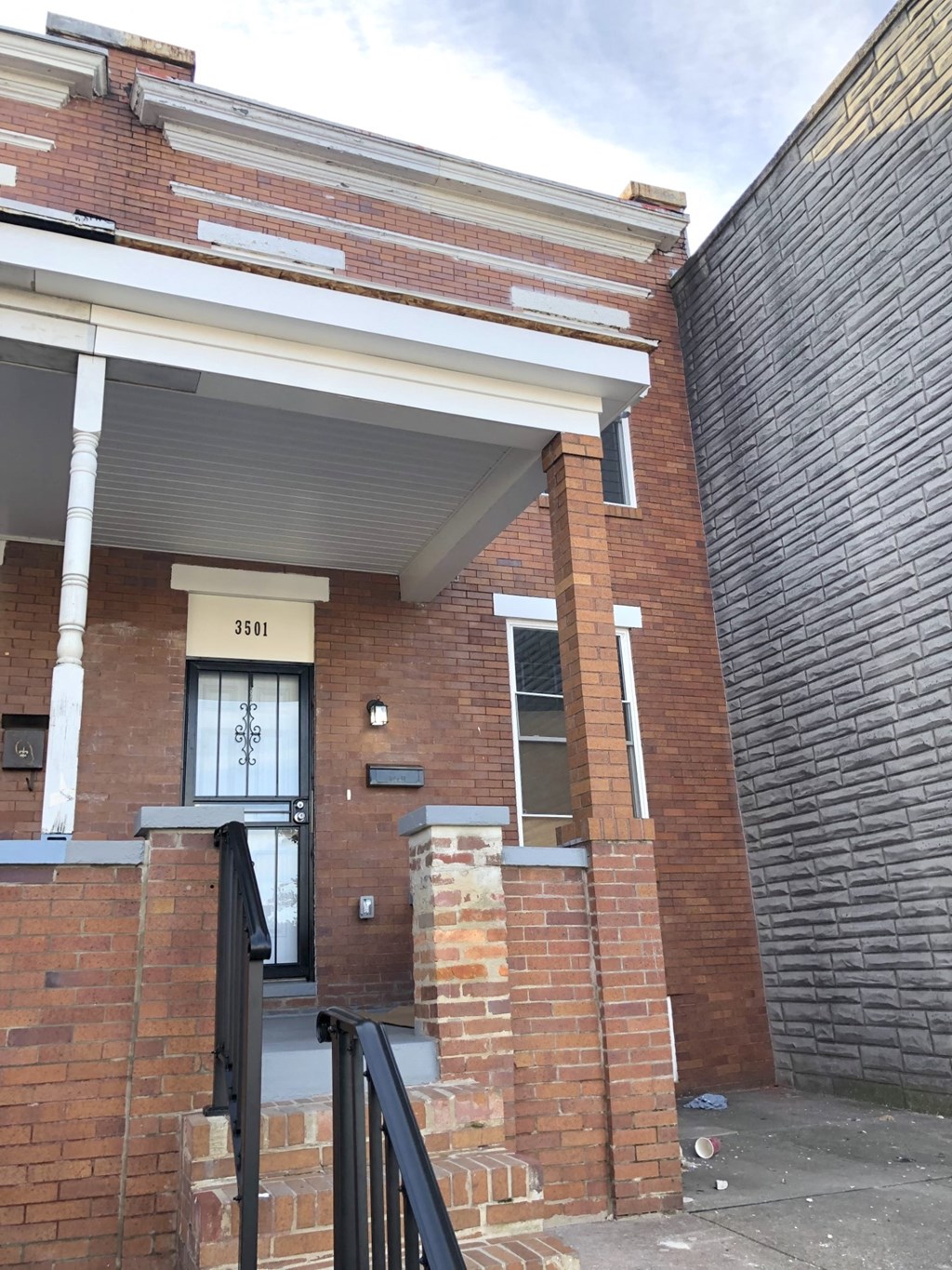 the front of a brick building with a door and stairs