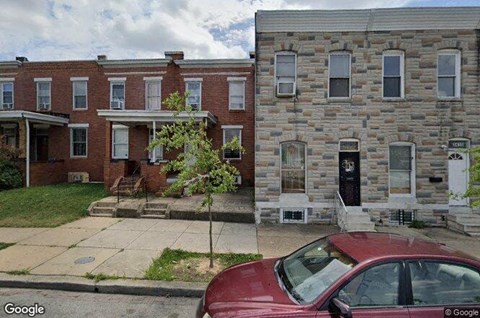 a red car parked in front of a brick building