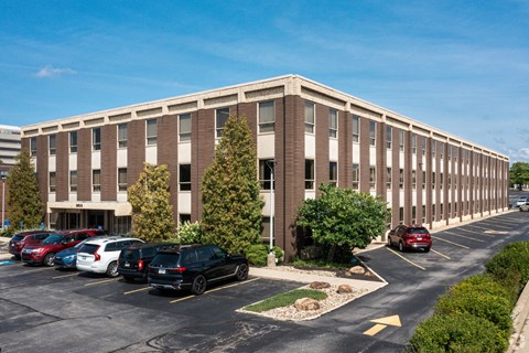 an office building with cars parked in a parking lot