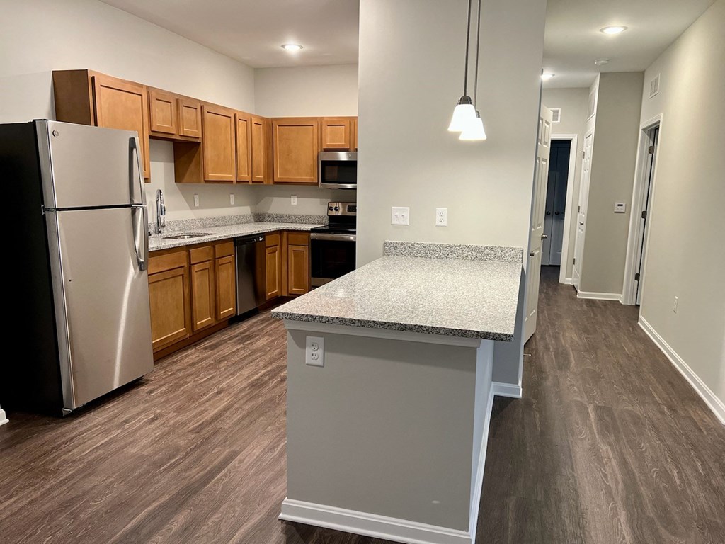 a kitchen with a granite counter top and a stainless steel refrigerator
