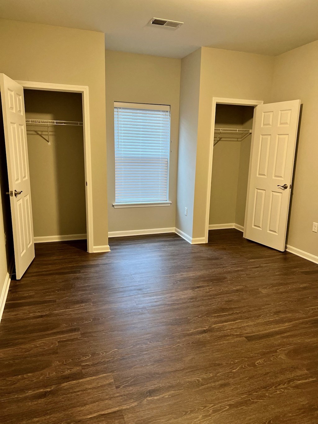 an empty living room with wood floors and a closet