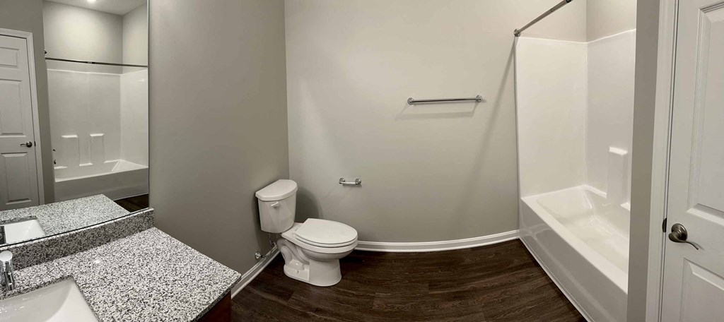 a bathroom with a toilet and a shower and a sink