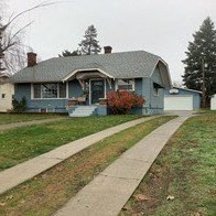 A house with a grey roof and a white garage door.