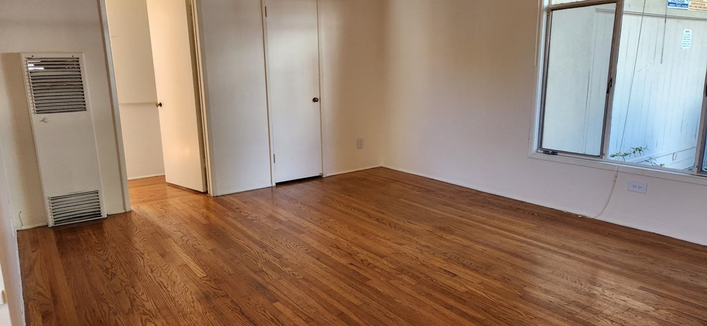 a living room with a hard wood floor and a window